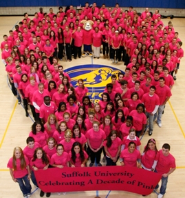Students and Staff standing in the shape of a ribbon all wearing neon pink t-shirts