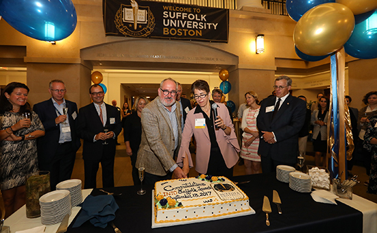 INTO University Partnerships Chief Executive Officer John Latham and Acting President Marisa Kelly cut the cake at the launch celebration during INTO's familiarization visit to Suffolk's Boston campus
