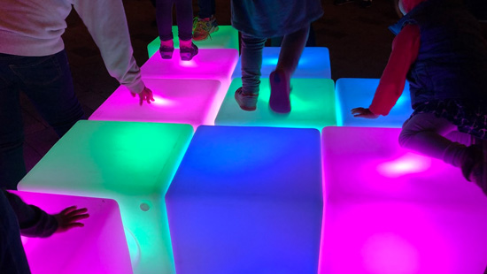 Hands and feet of children climbing on lighted blocks