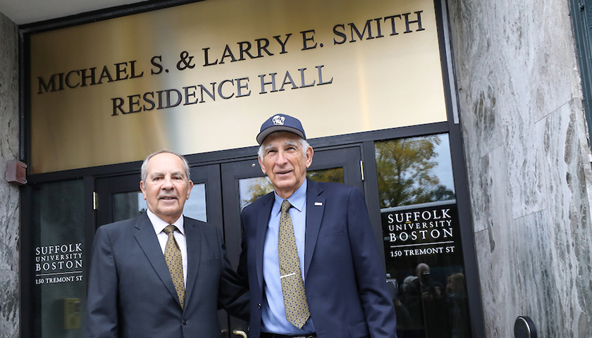 Michael and Larry Smith beneath the residence hall sign bearing their names