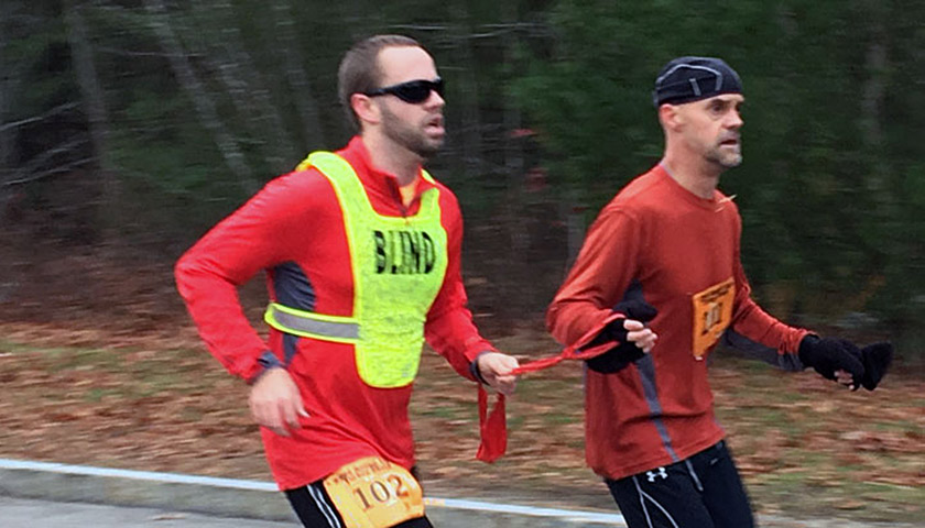 Ethics and Public Policy student Brian Switzer runs a Turkey Trot race with his guide, Mike.