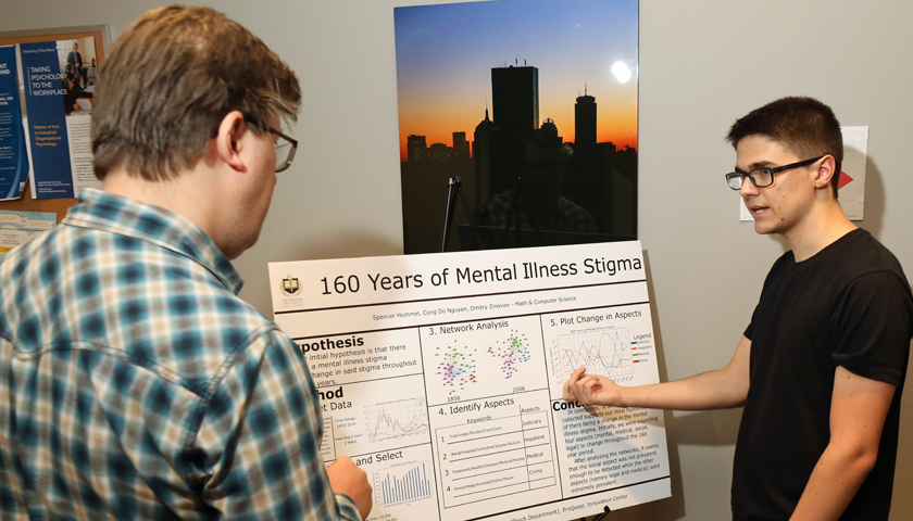 Professor Dmitry Zinoviev and Spencer Hommel examine charts