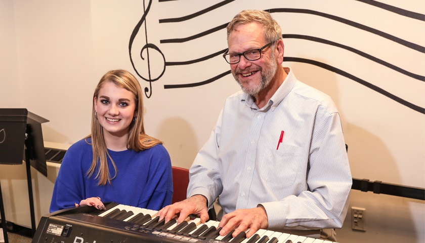 Ryan Coyle sits with Professor R. Harrison Kelton at keyboard