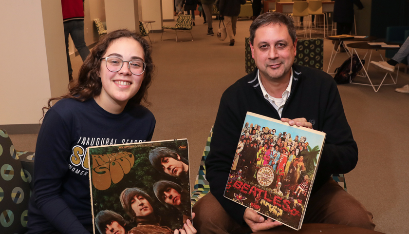 Laurana Quesada holds Rubber Soul LP album cover and David Gallant holds Sargent Pepper LP album cover