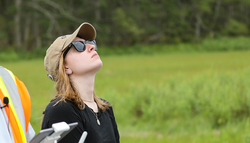 Tedy Feijoo with head pointed up to watch the drone