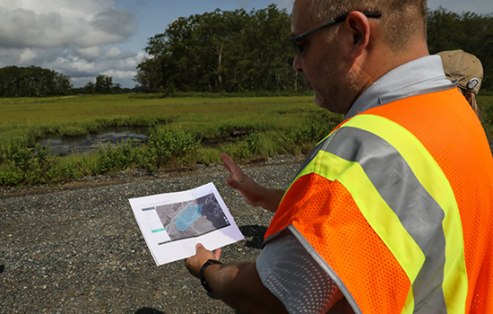 Scott Lussier holds map showing drone flight pattern