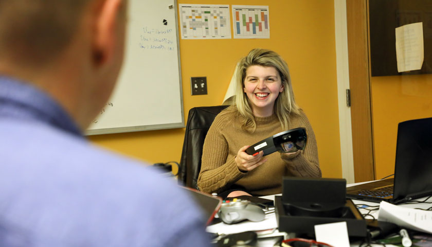 Molly McDonough holds augmented reality glasses in lab