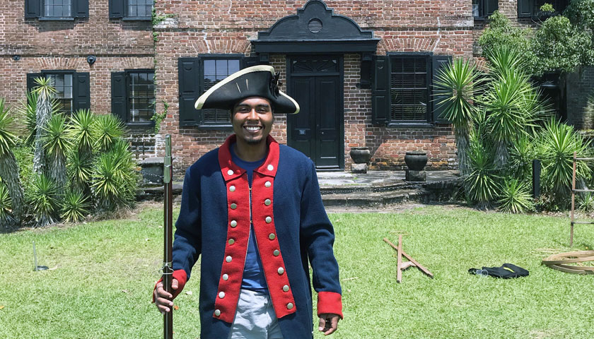 Nick Nunez tries on a historical costume outside a Middleton Place building