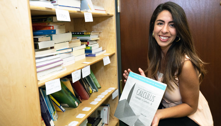 Anastasia Moawde with collected books