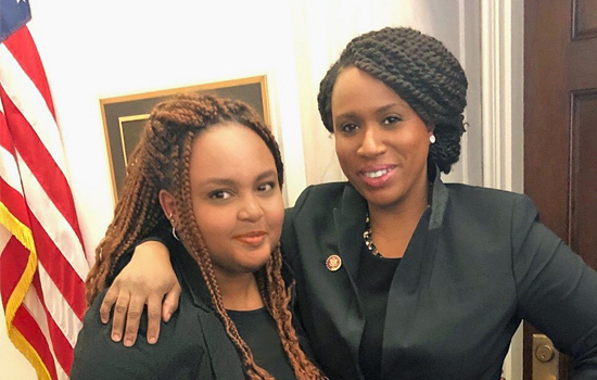 Congresswoman Ayanna Pressley puts an arm over Sara Solomon's shoulder