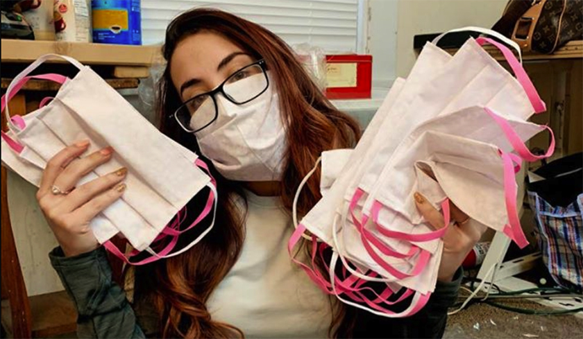 Amanda Ricko wearing mask and holding masks in both hands