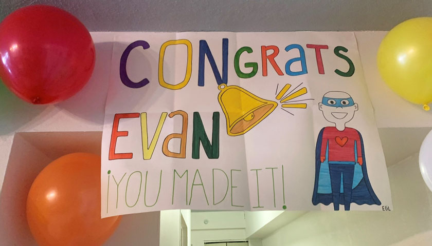 Sign surrounded by balloons says "Congrats Evan"