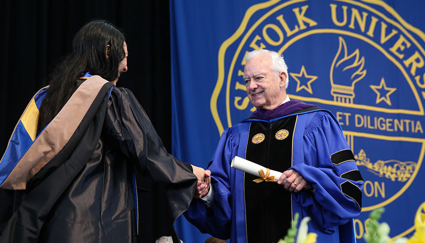 Dean O'Neill shakes hands with a student at Commencement
