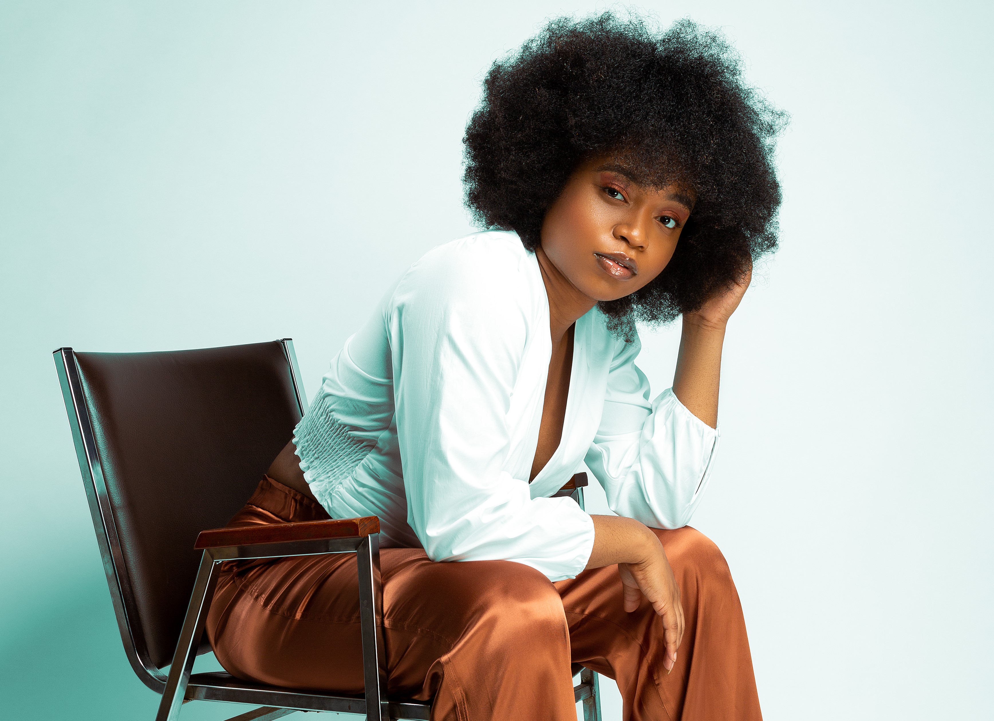 Alexandria Onuoha sits in front of a blue background