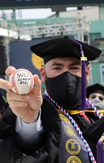 A Law School graduate celebrates commencement at Fenway Park