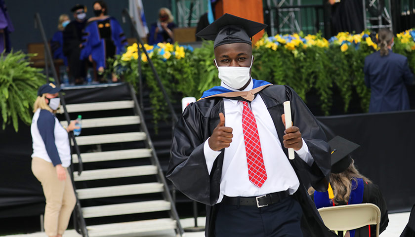 A brand new Sawyer Business School graduate celebrates his accomplishment