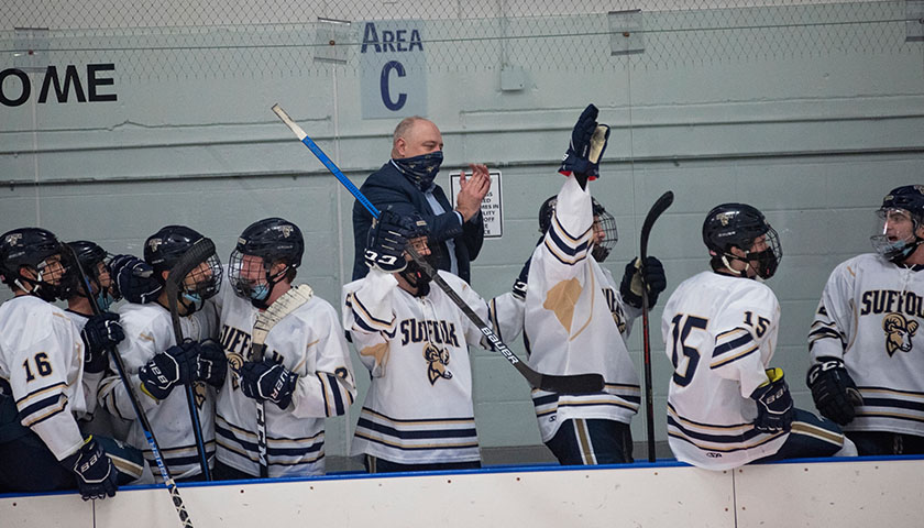 Hockey team and Head Coach Chris Glionna celebrate after a goal