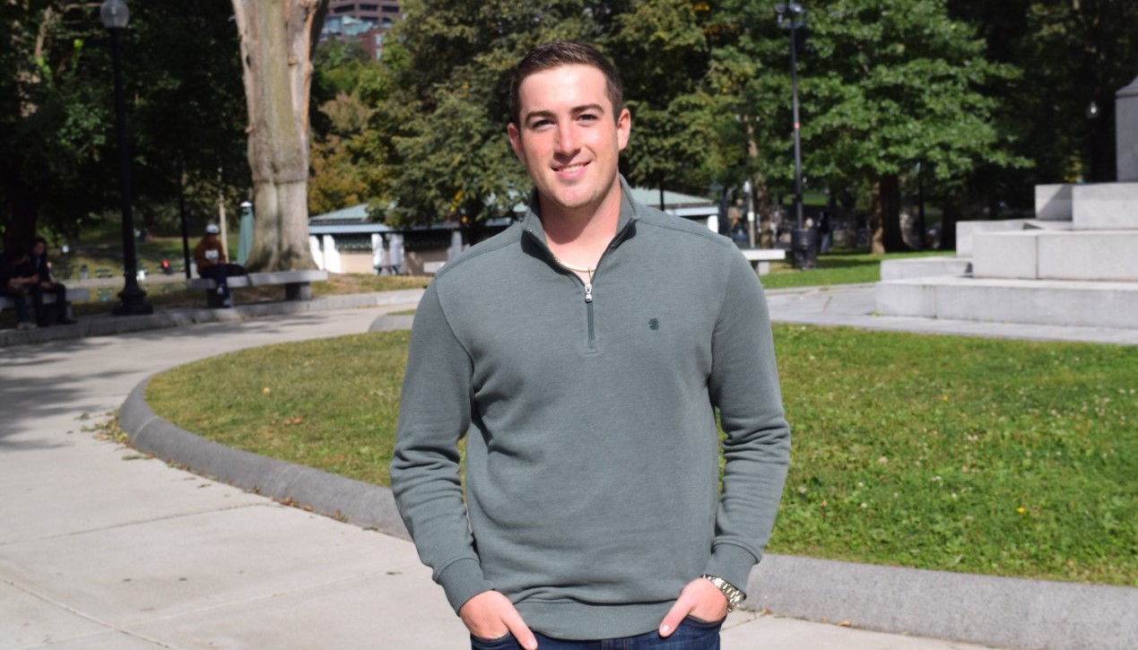 Steven Rossi stands outside, smiling, in street clothes