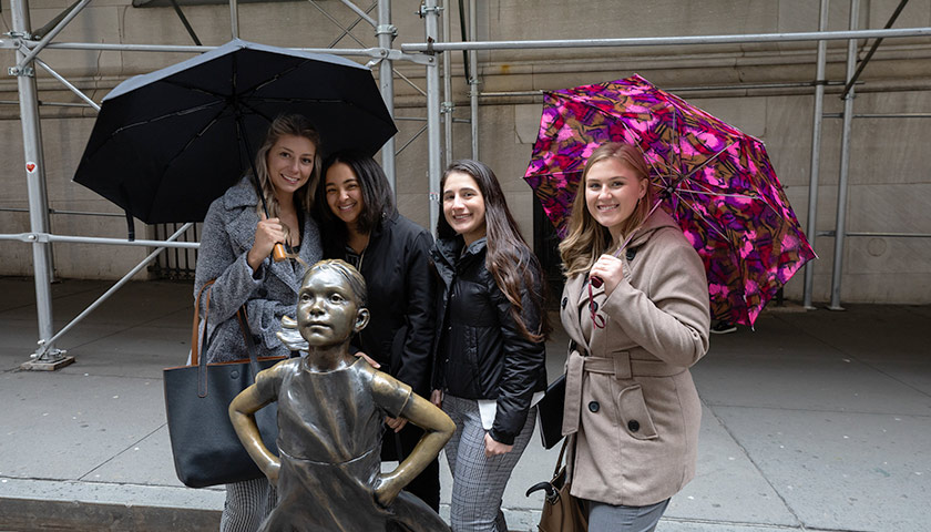 Sydney Watson, BSBS '21 (second from left) visits Fearless Girl
