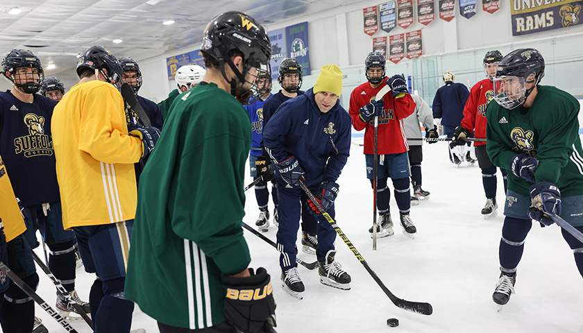 Coach Shawn McEachern on the ice with some of the Suffolk Men's Hockey Team