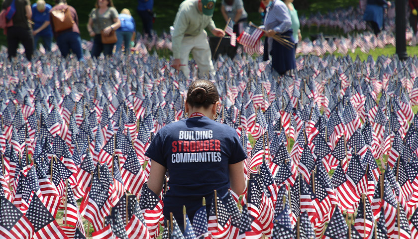 Hannah Arroyo standing in a field of flags as part of an event for vets and military families