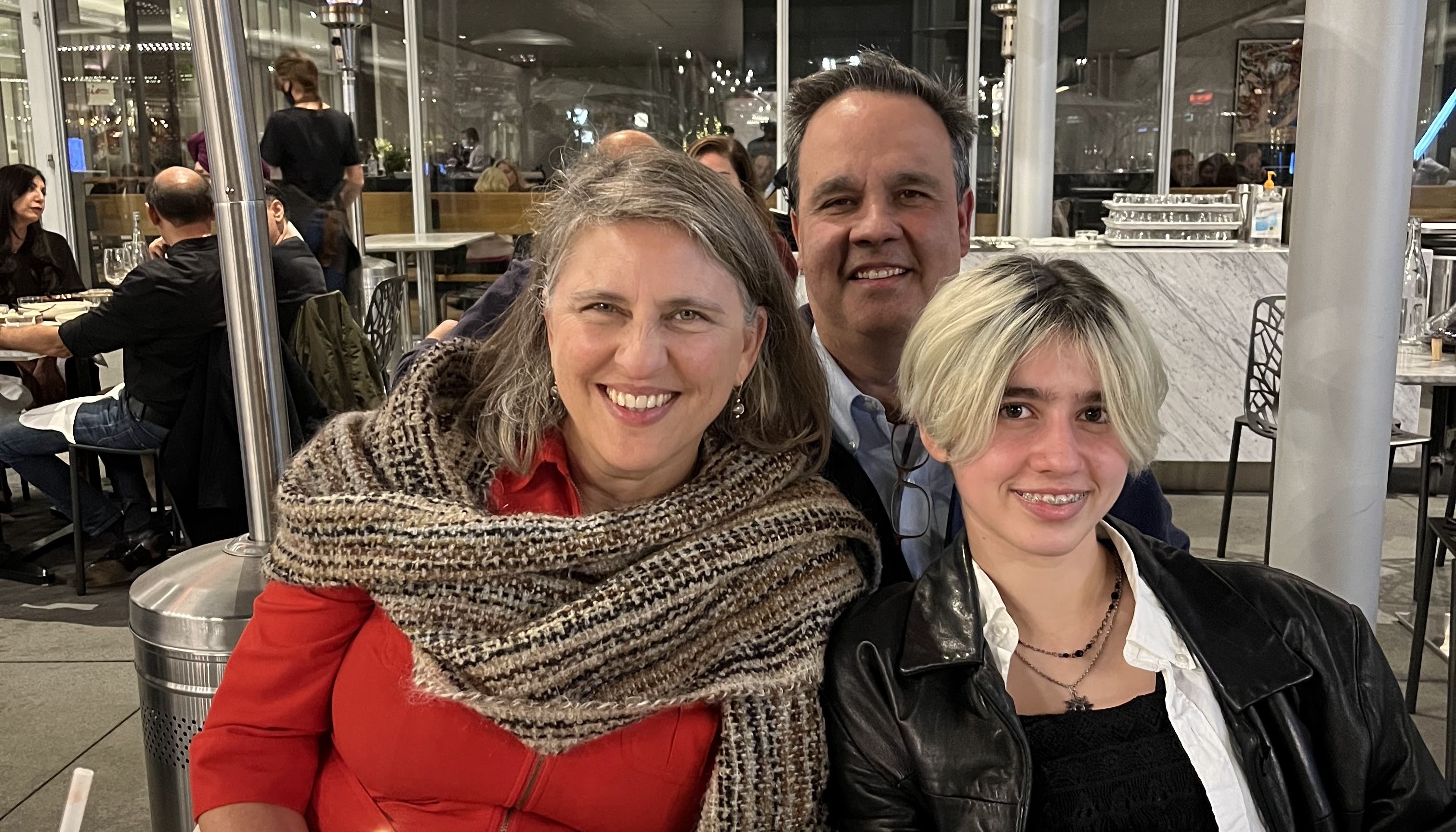 Edie Sparks smiles with her husband, Rick, and kid, Ada, at a restaurant