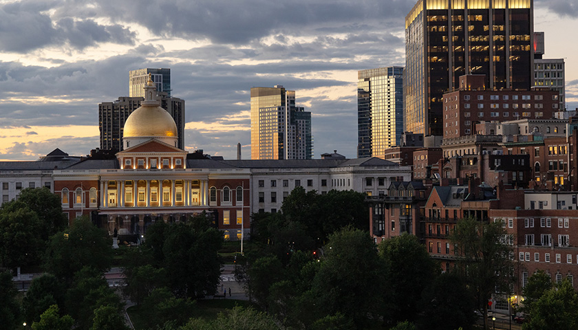 Picture of the Massachusetts State House and other Beacon Hill buildings in the distance as the sun sets into the clouds