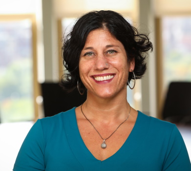 Headshot of Lauren Nolfo Clements smiling in a blue shirt