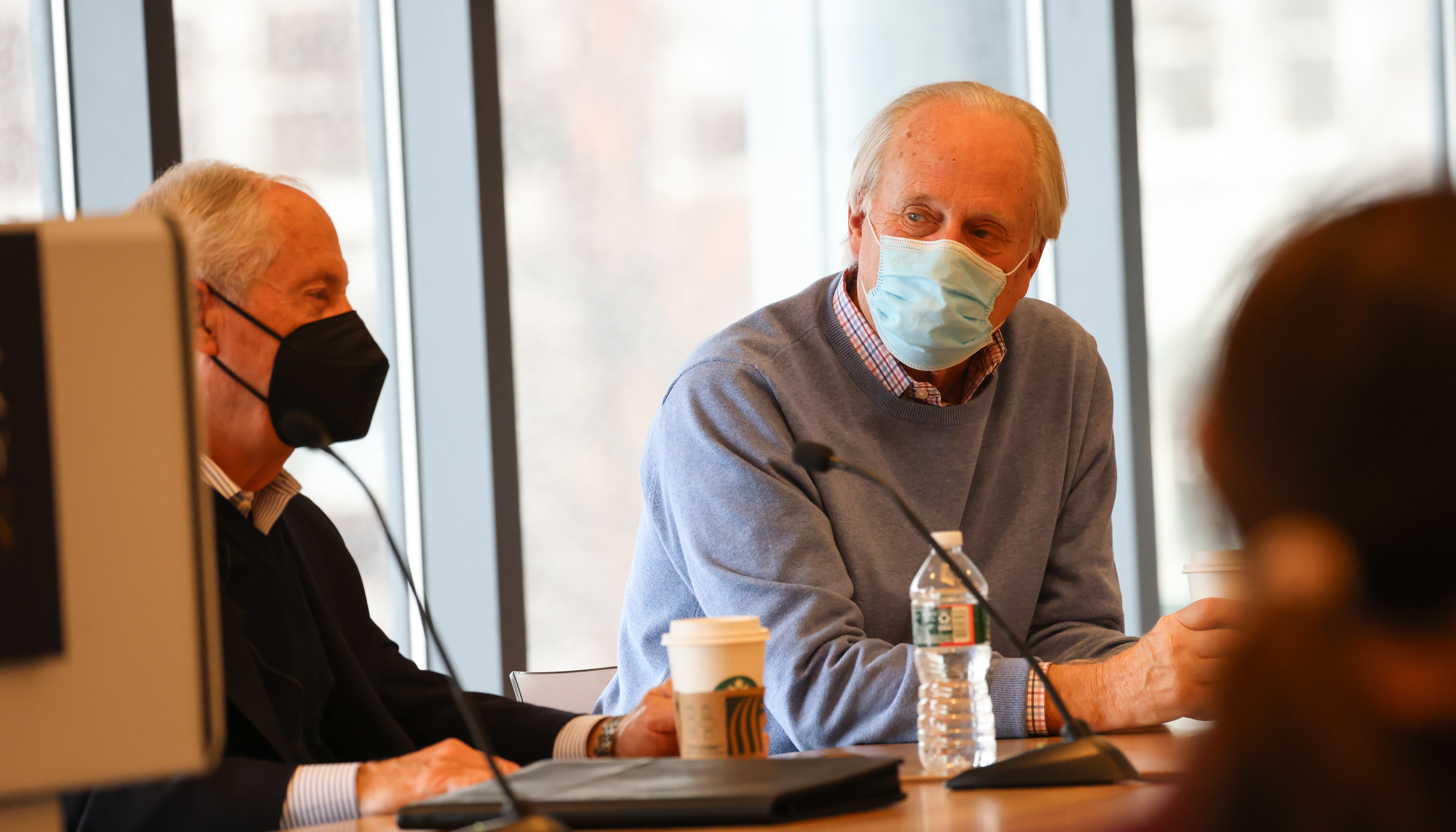 Former U.S. Reps Larry LaRocco and Scott Klug wear masks as they speak while seated as a table