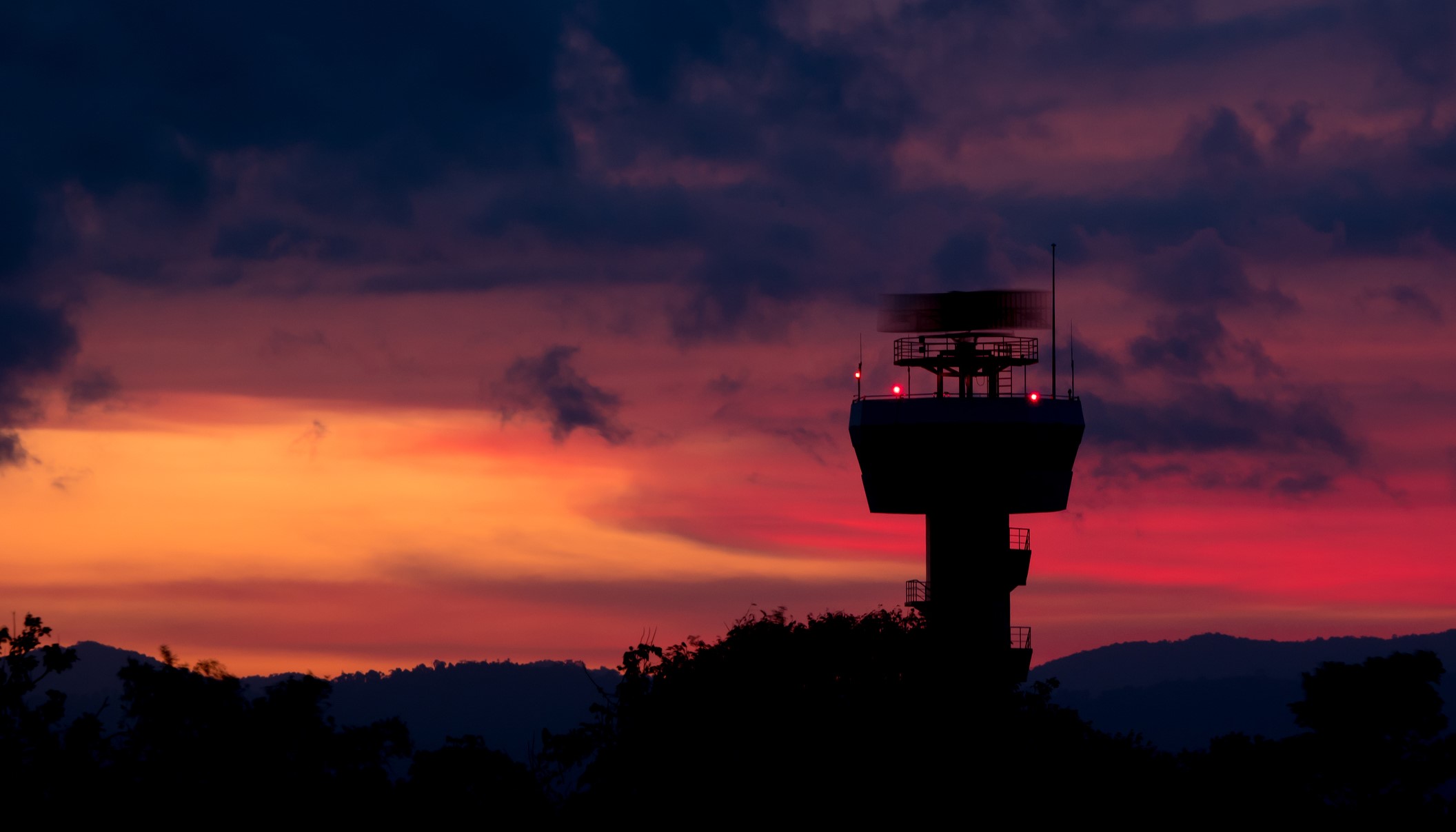 Silhouette of a prison watchtower against a sunset
