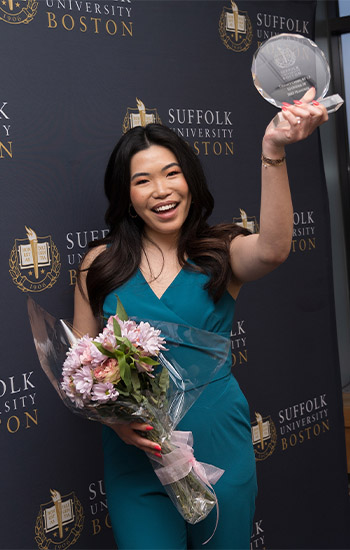 WBZ reporter Tiffany Chan hold her 10 Under 10 award over her head