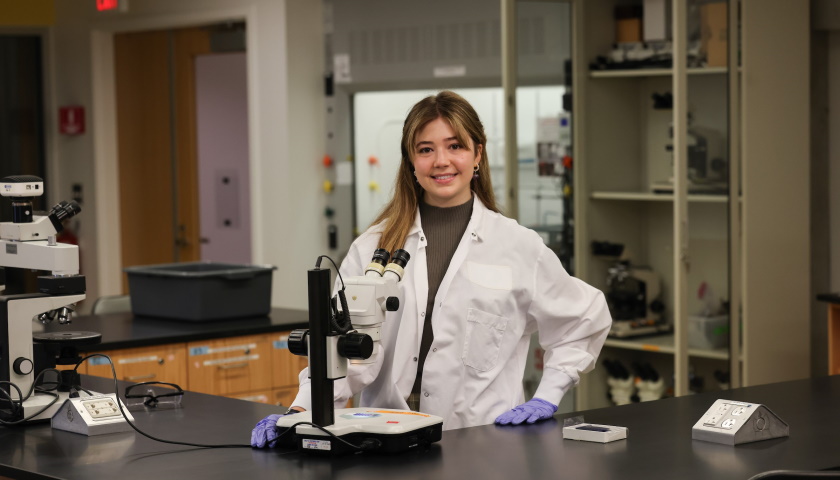 Victoria Arinella looks up from her microscope in the lab