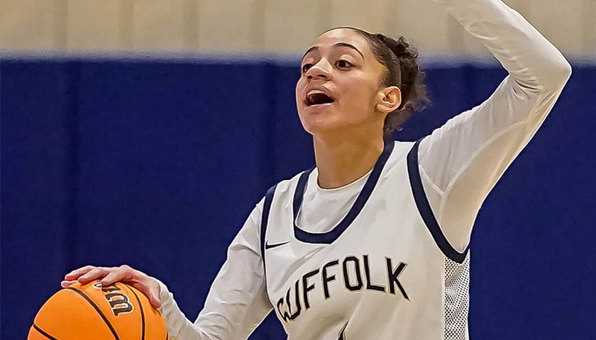 Arlenis Veloz dribbles a basketball with her left hand and signals a teammate with her upraised right hand