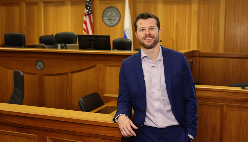 Brendan Kelly stands in the Suffolk Law mock courtroom