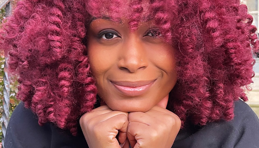 Closeup portrait of activist and author Feminista Jones resting her chin on her hands