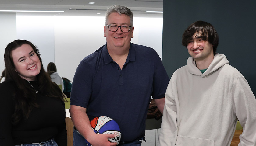 Students Emma Munroe and Miles Mazzotta share a laugh with Professor Richard Miller