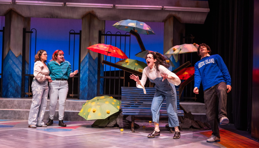 Students perform onstage during midSummer Kinda surrounded by colorful umbrellas