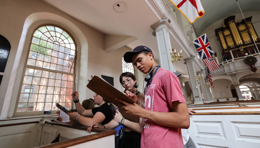 Students look at a clipboard of information as the tour inside Boston's historic Old North Church