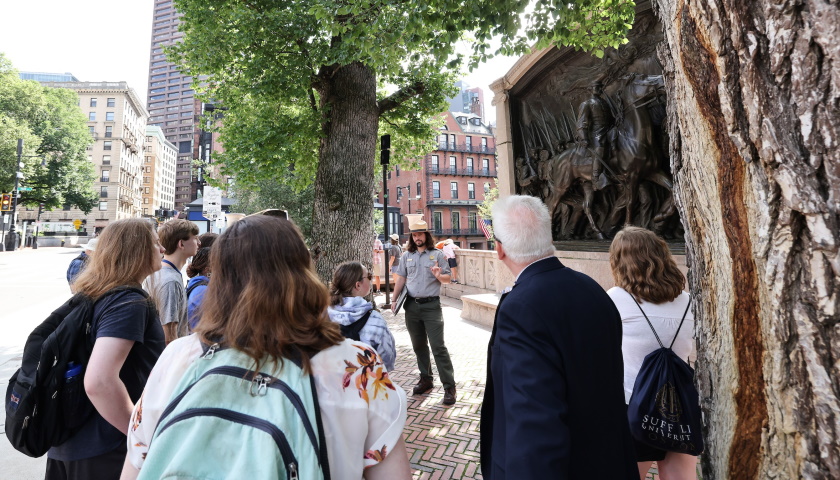 A National Park Service guide speaks with public history students in front of the Shaw Memorial in Boston