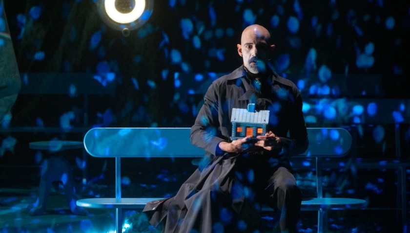 Nael Nacer sits on a bench onstage during a performance of The Orchard