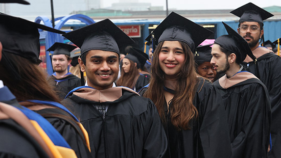 SBS students smile in the line as they enter Leader Bank Pavilion for Commencement