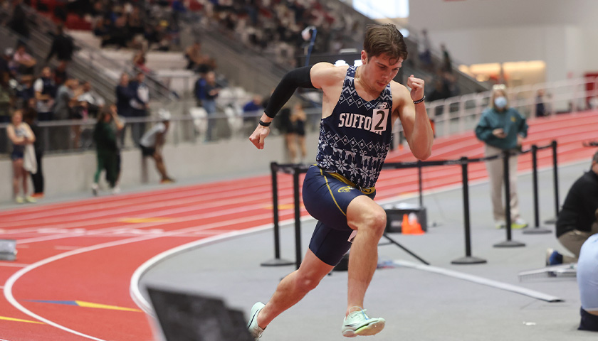 Turner Mitchell sprinting around the curve of an indoor track