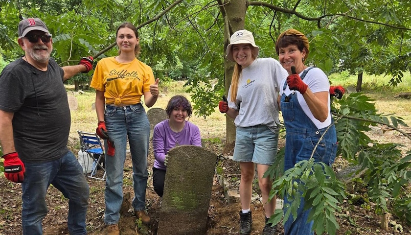 Three students pose with Professor Barbara Abrams and her husband, Rabbi David Kudan, in Bagnowka Jewish Cemetery