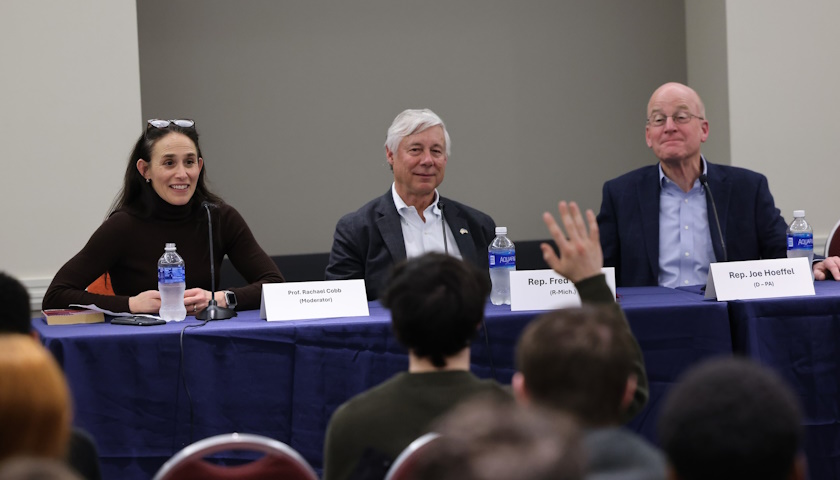 Professor Rachael Cobb and Former US Representatives Fred Upton and Joe Hoeffel sit in front of attendees at a Running for Office 101 panel as an attendee raises their hand