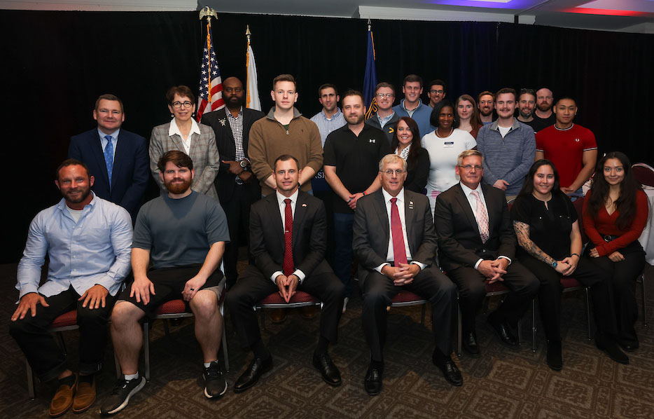 Alumni- and student-veterans gather with University leaders after the event.