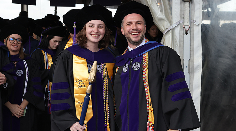Two Suffolk Law graduates smiling at the camera at the 2025 Commencement