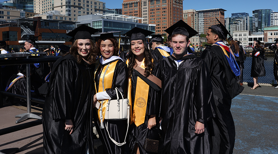 students in regalia line up before Commencement 2025