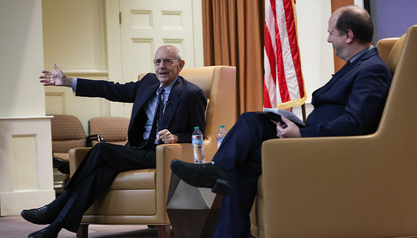 Justice Stephen Breyer gestures while speaking to a packed audience of Suffolk students, while Professor Greg Bordelon looks on