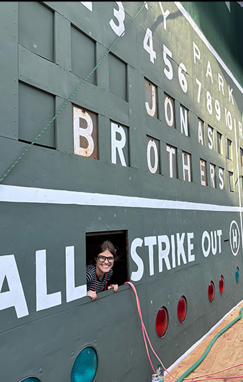 Anja Wight peeking out of the scoreboard at Fenway Park ahead with "Jonas Brothers' in the scoreboard above her