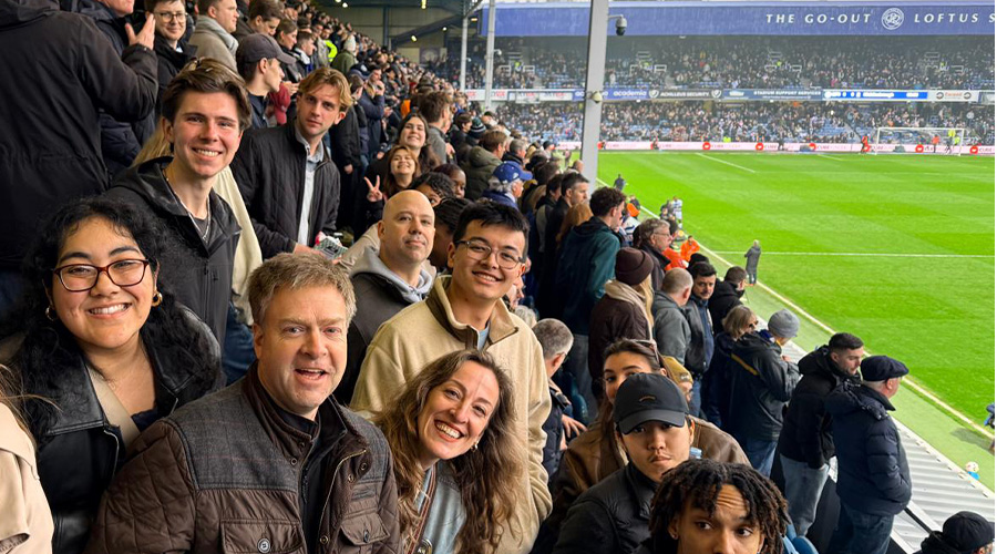 Suffolk students and professors in the stands at a Queens Park Rangers game